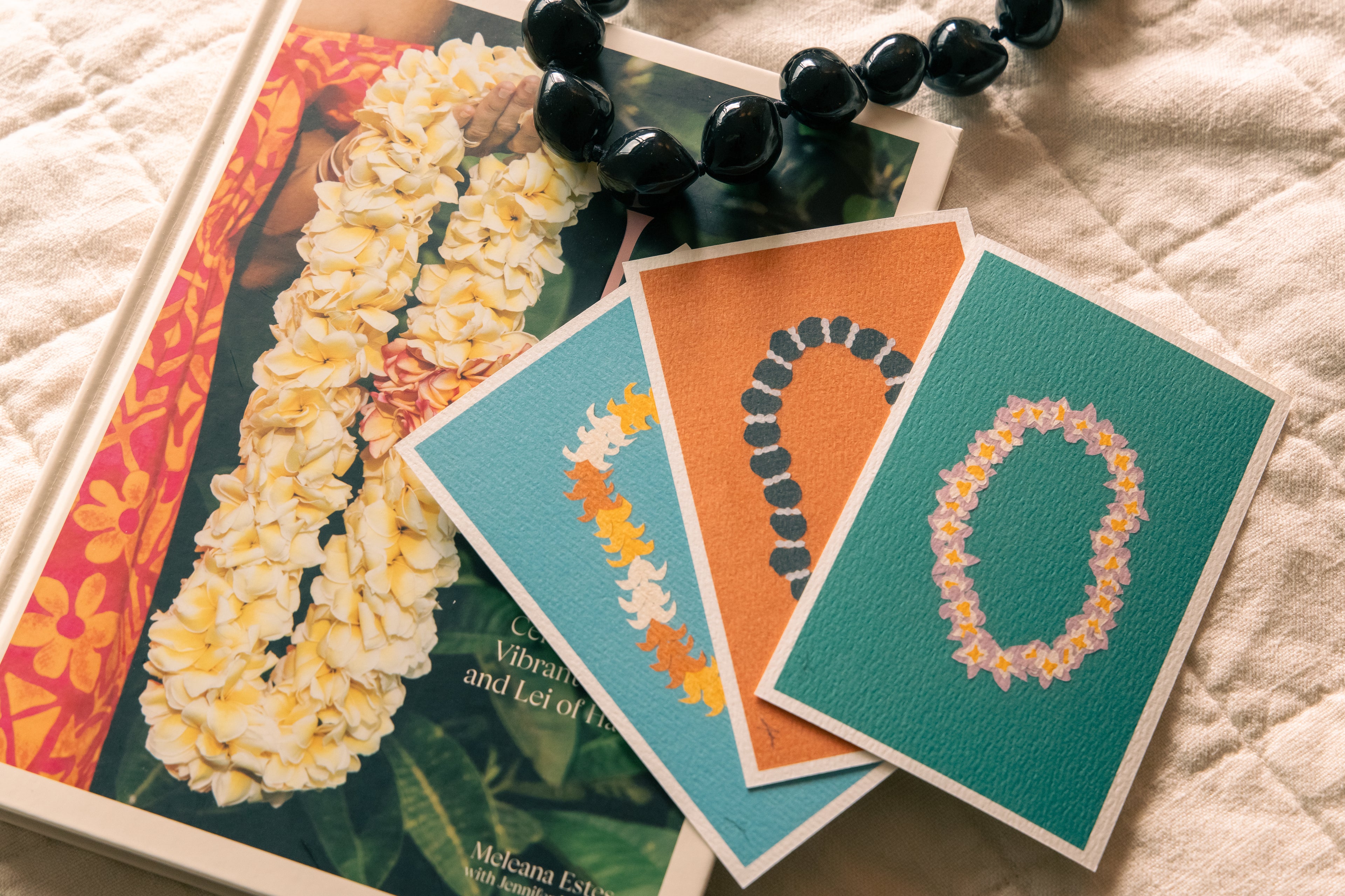 Three greeting cards with leis designs on a textured surface